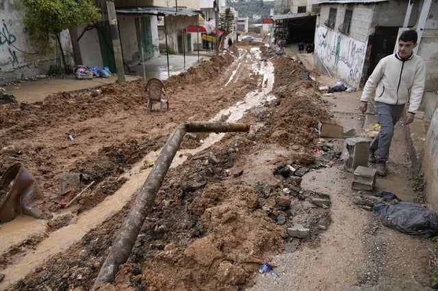A Palestinian boy walks along the main road of the Far'a refugee camp that was bulldozed by the Israeli military, after the withdrawal of Israeli troops from Far'a, near the West Bank city of Tubas Wednesday, Feb. 12, 2025. (AP Photo/Nasser Nasser)