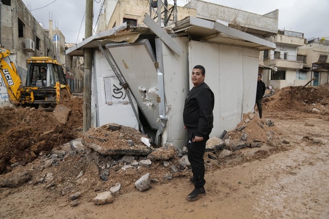 Mohammed Yacoub, 25 stands at his demolished kiosk along a main road that was bulldozed by the Israeli military during its operation in the Far'a refugee camp, near the West Bank city of Tubas, Wednesday, Feb. 12, 2025. (AP Photo/Nasser Nasser)