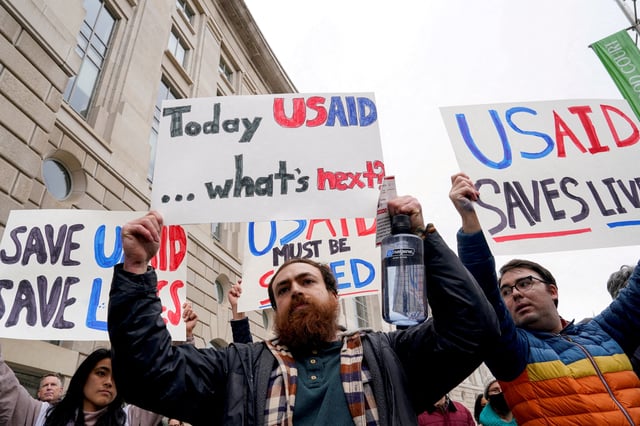 People hold placards outside the USAID building, after billionaire Elon Musk, who is heading U.S. President Donald Trump's drive to shrink the federal government, said work is underway to shut down the U.S. foreign aid agency USAID, in Washington, U.S., February 3, 2025. REUTERS/Kent Nishimura/File Photo