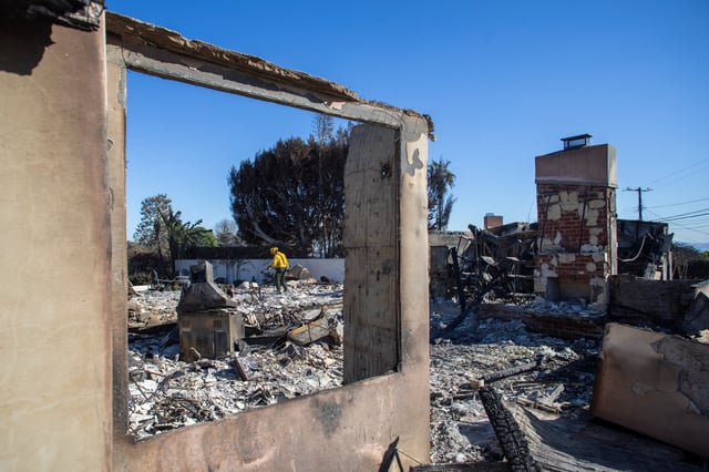 Firefighters inspect a house burned in the Palisades Fire in the Pacific Palisades neighborhood on January 15, 2025 in Los Angeles, California.