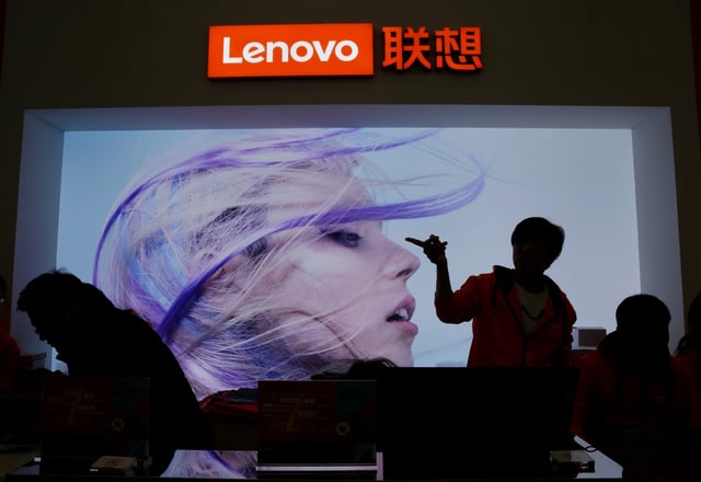 An employee gestures next to a Lenovo logo at Lenovo Tech World in Beijing, China November 15, 2019. REUTERS/Jason Lee/File Photo