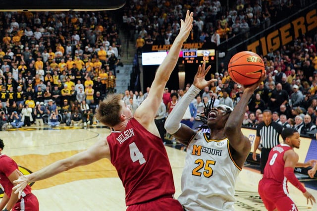 Feb 19, 2025; Columbia, Missouri, USA; Missouri Tigers guard Mark Mitchell (25) shoots as Alabama Crimson Tide forward Grant Nelson (4) defends during the second half at Mizzou Arena. Mandatory Credit: Denny Medley-Imagn Images