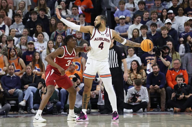Feb 19, 2025; Auburn, Alabama, USA;  Auburn Tigers forward Johni Broome (4) looks for help as Arkansas Razorbacks forward Adou Thiero (3) defends during the firs half at Neville Arena. Mandatory Credit: John Reed-Imagn Images