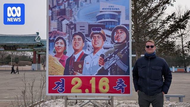 a man standing in front of a sign