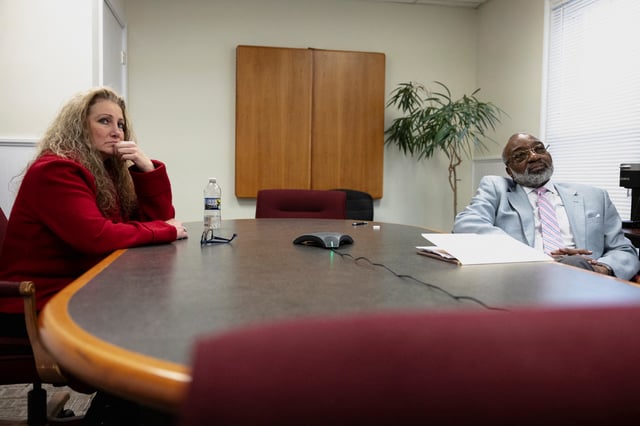 Marlean Ames sits with Edward Gilbert, her lawyer, during a meeting in his law office in Akron, Ohio, U.S., February 13, 2025. REUTERS/Megan Jelinger