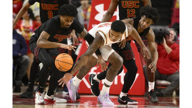 USC guards Chibuzo Agbo, left, and Wesley Yates III, right, battle for the ball against Maryland forward Julian Reese during the first half of a Big Ten game on Thursday night in College Park, Md. (AP Photo/Nick Wass)