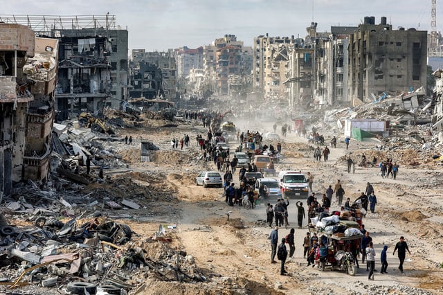 People walk past the rubble of collapsed buildings along Saftawi street in Jabalia in the northern Gaza Strip on January 20.