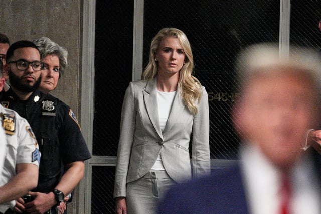 Natalie Harp listens as Donald Trump speaks outside of the courtroom during his trial for allegedly covering up hush money payments at Manhattan Criminal Court on April 30, 2024 in New York City.