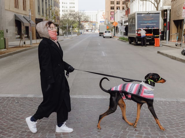 Yale Padilla walks her dog, Chilanga, who is wearing a traditional Mexican-style dog coat, on a cold Thursday morning when temperatures dipped down into the 20s in San Antonio.