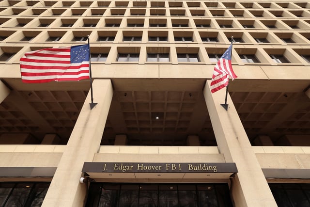 Flags fly over an entrance to FBI headquarters, days after the Trump administration launched a sweeping round of cuts at the Justice Department, in Washington, U.S., February 3, 2025. REUTERS/Kevin Lamarque/File Photo