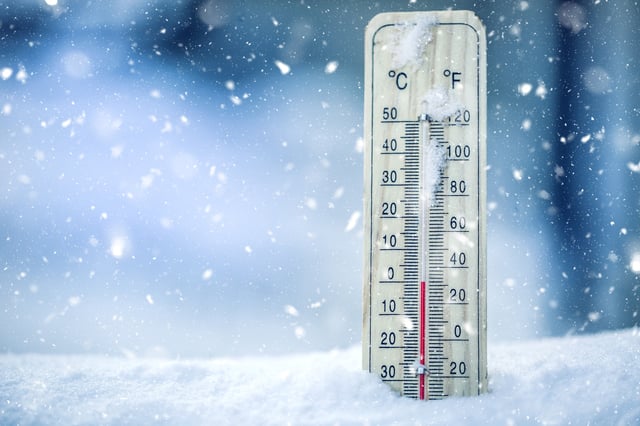 A stock photo of a thermometer in cold weather.