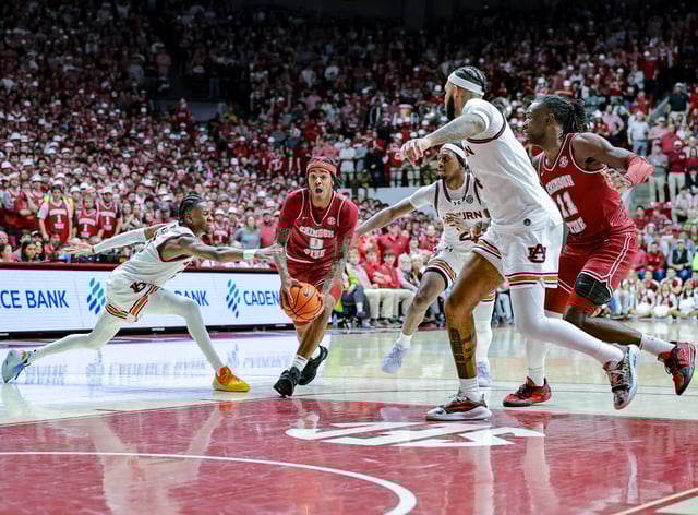 Labaron Philon #0 of the Alabama Crimson Tide drives to the basket during the second half between a trio of Auburn Tigers defenders at Coleman Coliseum on February 15, 2025 in Tuscaloosa, Alabama.