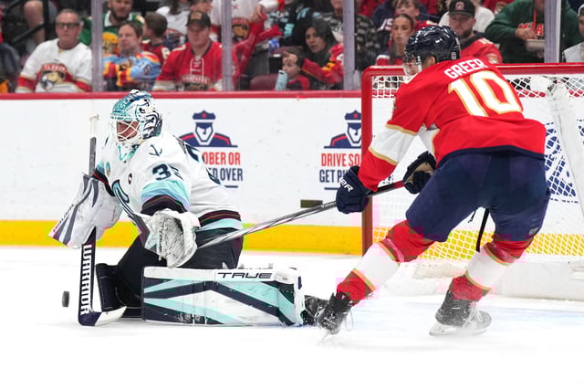 Feb 22, 2025; Sunrise, Florida, USA;  Seattle Kraken goaltender Joey Daccord (35) makes a save as Florida Panthers left wing A.J. Greer (10) closes in during the second period at Amerant Bank Arena. Mandatory Credit: Jim Rassol-Imagn Images