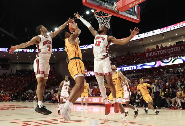 Feb 22, 2025; Houston, Texas, USA; Iowa State Cyclones center Dishon Jackson (1) is defended by Houston Cougars forward J'Wan Roberts (13) and  guard Milos Uzan (7) in the second half at Fertitta Center. Mandatory Credit: Thomas Shea-Imagn Images
