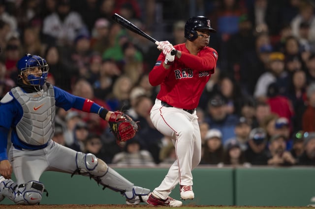 BOSTON, MA - APRIL 26: Rafael Devers #11 of the Boston Red Sox hits a single during the fourth inning of a game against the Chicago Cubs on April 26, 2024 at Fenway Park in Boston, Massachusetts.