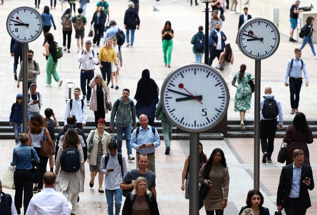 Workers walk through the Canary Wharf financial district, ahead of a Bank of England decision on interest rate changes, in London, Britain, August 3, 2023. REUTERS/Toby Melville/File Photo