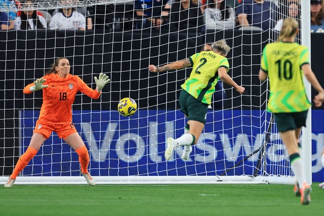 Feb 23, 2025; Glendale, Arizona, USA; Australia forward Michelle Heyman (2) scores a goal against USA goal keeper Mandy McGlynn (18) during the second half in the SheBelieves Cup at State Farm Stadium. Mandatory Credit: Mark J. Rebilas-Imagn Images