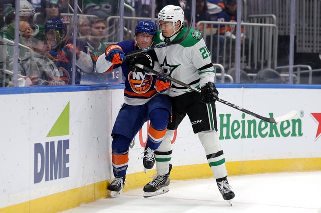 Feb 23, 2025; Elmont, New York, USA; Dallas Stars left wing Jason Robertson (21) hits New York Islanders defenseman Scott Perunovich (26) during the third period at UBS Arena. Mandatory Credit: Brad Penner-Imagn Images