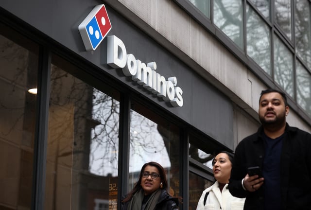 A person walks past a Domino's pizza restuarant in London, Britain, March 4, 2023. REUTERS/Henry Nicholls/File Photo