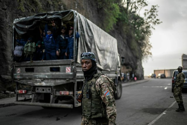 Menschen in Militäruniformen auf einem Transporter.
