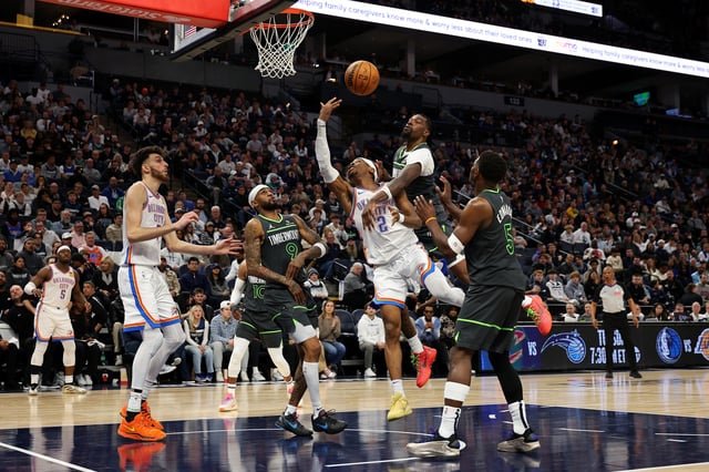 Naz Reid #11 of the Minnesota Timberwolves blocks a shot by Shai Gilgeous-Alexander #2 of the Oklahoma City Thunder in the fourth quarter at Target Center on February 23, 2025 in Minneapolis, Minnesota. The Thunder defeated the Timberwolves 130-123.