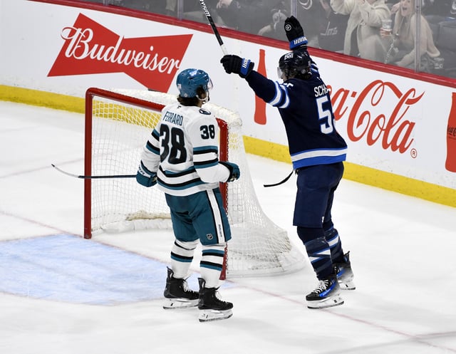 Winnipeg Jets' Mark Scheifele (55) celebrates his game-winning goal in overtime in front of San Jose Sharks' Mario Ferraro (38) during NHL hockey action in Winnipeg, Monday, Feb. 24, 2025. THE CANADIAN PRESS/Fred Greenslade