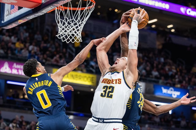 Feb 24, 2025; Indianapolis, Indiana, USA; Denver Nuggets forward Aaron Gordon (32) shoots the ball while Indiana Pacers guard Tyrese Haliburton (0) and forward Aaron Nesmith (23) defend in the second half at Gainbridge Fieldhouse. Mandatory Credit: Trevor Ruszkowski-Imagn Images