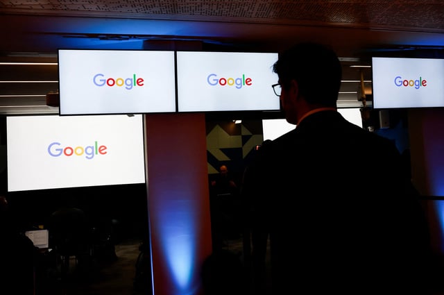 A man stands in front of Google logos during a media reception at the Google France headquarters ahead of the Artificial Intelligence Action Summit in Paris, France, February 9, 2025. REUTERS/Gonzalo Fuentes/ File Photo