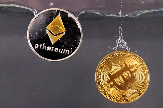 Souvenir tokens representing cryptocurrency Bitcoin and the Ethereum network, with its native token ether, plunge into water in this illustration taken May 17, 2022. REUTERS/Dado Ruvic/Illustration/File Photo