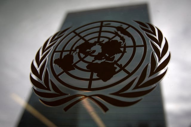 The United Nations headquarters building is pictured though a window with the UN logo in the foreground in the Manhattan borough of New York August 15, 2014.    REUTERS/Carlo Allegri/File Photo