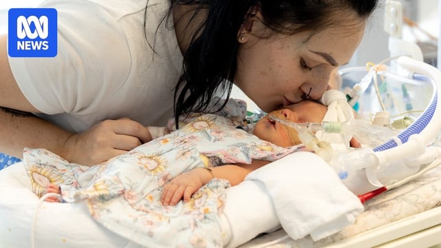 A woman kisses a baby.