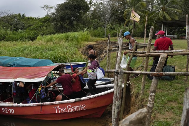 Venezuelan migrant Gabriela Villanueva, center, carries her daughter onto a boat in Puerto Cartí, Panama, Sunday, Feb. 23, 2025, en route to the Caribbean island of Gardi Sugdub. From there, she plans to return home via Colombia, after abandoning hopes of reaching the U.S. amid President Trump's immigration crackdown. (AP Photo/Matias Delacroix)