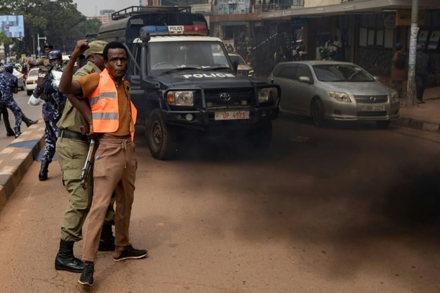 Ugandan police officers arrest an environmental activist taking part in a protest in Kampala in August 2024