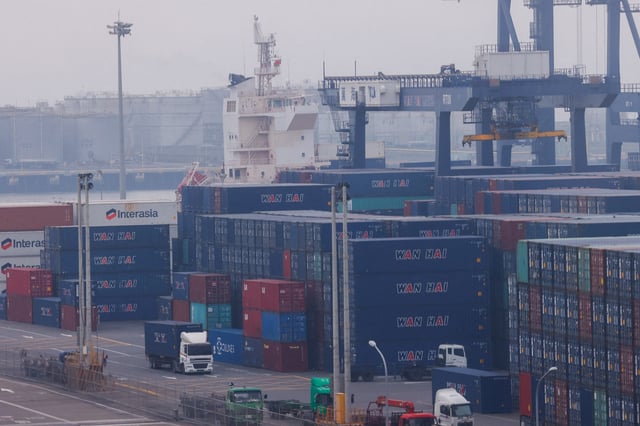 Trucks drive between cargo containers at Port of Taichung in Taichung, Taiwan April 18, 2023. REUTERS/Ann Wang/File Photo