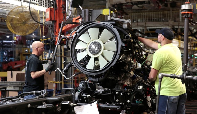 General Motors assembly workers attach the engine to the chassis of Chevrolet 2019 heavy-duty pickup trucks at General Motors Flint Assembly Plant in Flint, Michigan.