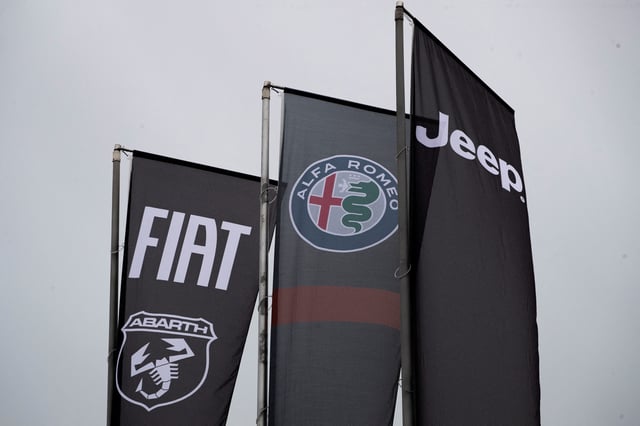 Banners showing logos of Fiat, Jeep, Abarth and Alfa Romeo are hung outside a car dealership in Milan, Italy, November 21, 2024.
