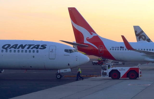 Workers are seen near Qantas Airways, Australia's national carrier, Boeing 737-800 aircraft on the tarmac at Adelaide Airport, Australia, August 22, 2018. REUTERS/David Gray/File Photo