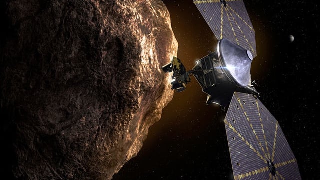 This illustration shows NASA’s Lucy spacecraft passing one of the Trojan asteroids near Jupiter. Image credit: Southwest Research Institute.
