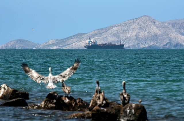 A tanker sails near an oil refining plant of state-owned Petroleos de Venezuela (PDVSA) in Puerto La Cruz in November 2021