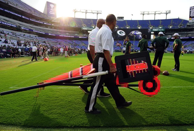 Chain crew members walk on the field prior to a game between the Green Bay Packers and Baltimore Ravens at M&T Bank Stadium.