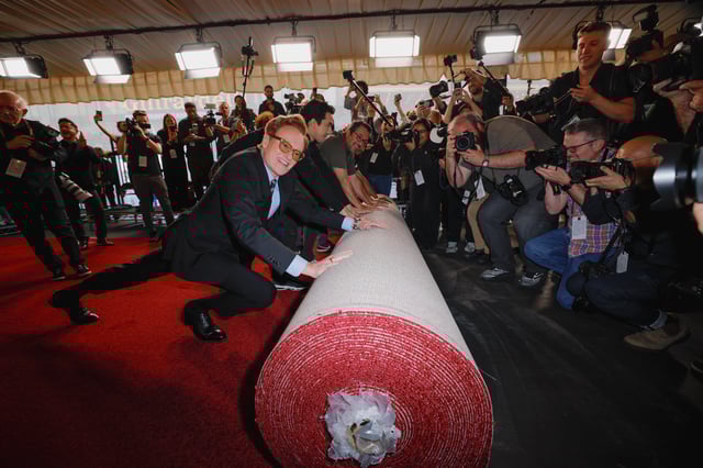 Academy Awards host Conan O'Brien pushes the rolled red carpet during its rollout for the 97th Academy Awards in Los Angeles, California, U.S., February 26, 2025. REUTERS/Mike Blake