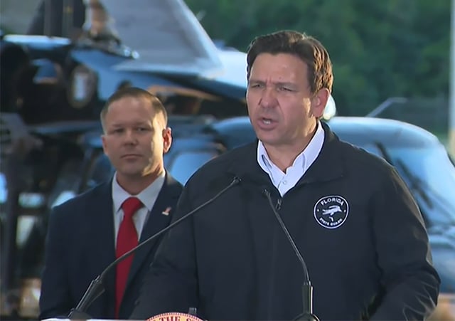 Department of Homeland Security Senior Counselor Keith Pearson and Florida Gov. Ron DeSantis at a Wednesday news conference at Homestead Air Force Base. (Florida Channel/Courtesy)