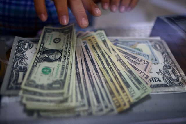 The employee of a currency exchange shop counts U.S. dollar banknotes in Ciudad Juarez, Mexico July 27, 2023. REUTERS/Jose Luis Gonzalez/File Photo
