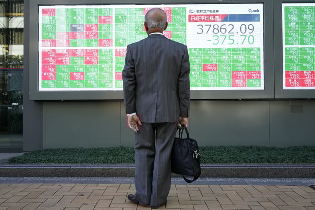 A person looks at an electronic stock board showing Japan's Nikkei index at a securities firm Wednesday, Feb. 26, 2025, in Tokyo. (AP Photo/Eugene Hoshiko)