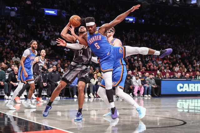 Feb 26, 2025; Brooklyn, New York, USA;  Brooklyn Nets forward Tosan Evbuomwan (12) looks to post up against Oklahoma City Thunder guard Luguentz Dort (5) in the third quarter at Barclays Center. Mandatory Credit: Wendell Cruz-Imagn Images
