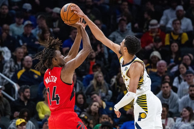 Feb 26, 2025; Indianapolis, Indiana, USA; Indiana Pacers guard Tyrese Haliburton (0) blocks the shot of Toronto Raptors guard Ja'Kobe Walter (14) in the second half at Gainbridge Fieldhouse. Mandatory Credit: Trevor Ruszkowski-Imagn Images