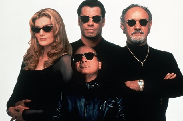 John Travolta (M.) zusammen mit Rene Russo (l.), Danny DeVito (vorn) und Gene Hackman (r.) in einer Filmszene von "Schnappt Shorty!"