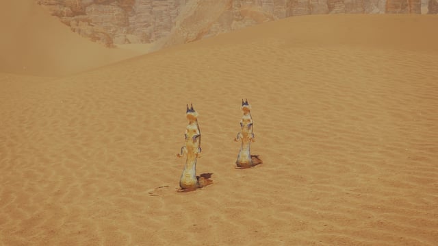 Two Track Tail Lizards in Monster Hunter Wilds standing out in the open sand. They're sitting propped up after just being frightened. 