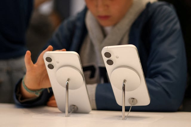 A child uses Apple iPhone smartphone displayed at a store in London, Britain, October 6, 2024. REUTERS/Hollie Adams/File Photo