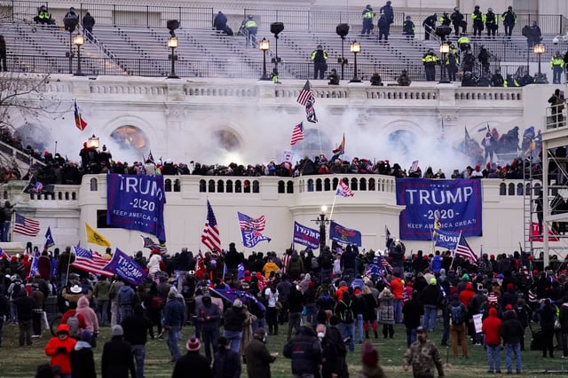 FILE - In this Jan. 6, 2021, file photo, violent protesters, loyal to then-President Donald Trump, storm the Capitol, Wednesday, Jan. 6, 2021, in Washington. Two Seattle police officers who were in Washington, D.C., during the January 6 insurrection were illegally trespassing on Capitol grounds while rioters stormed the building, but lied about their actions, a police watchdog said in a report released Thursday, July 8, 2021. (AP Photo/John Minchillo, File)